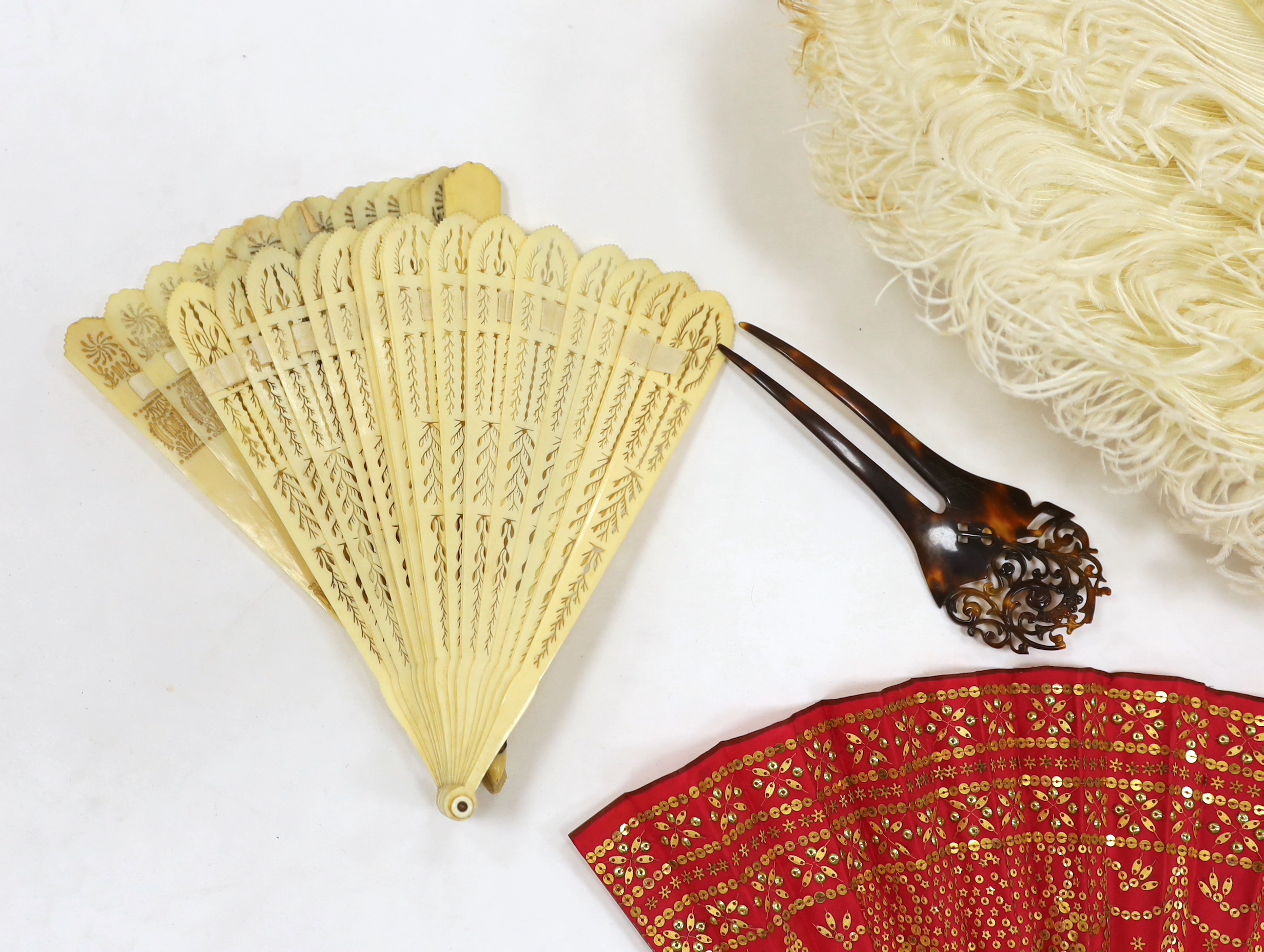 A Regency sequin and horn fan, a bone brise fan, a large white feather fan and a similar miniature fan and hat ornament two hair combs, etc